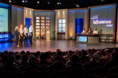 Four students presenting in front of a crowd during a competition